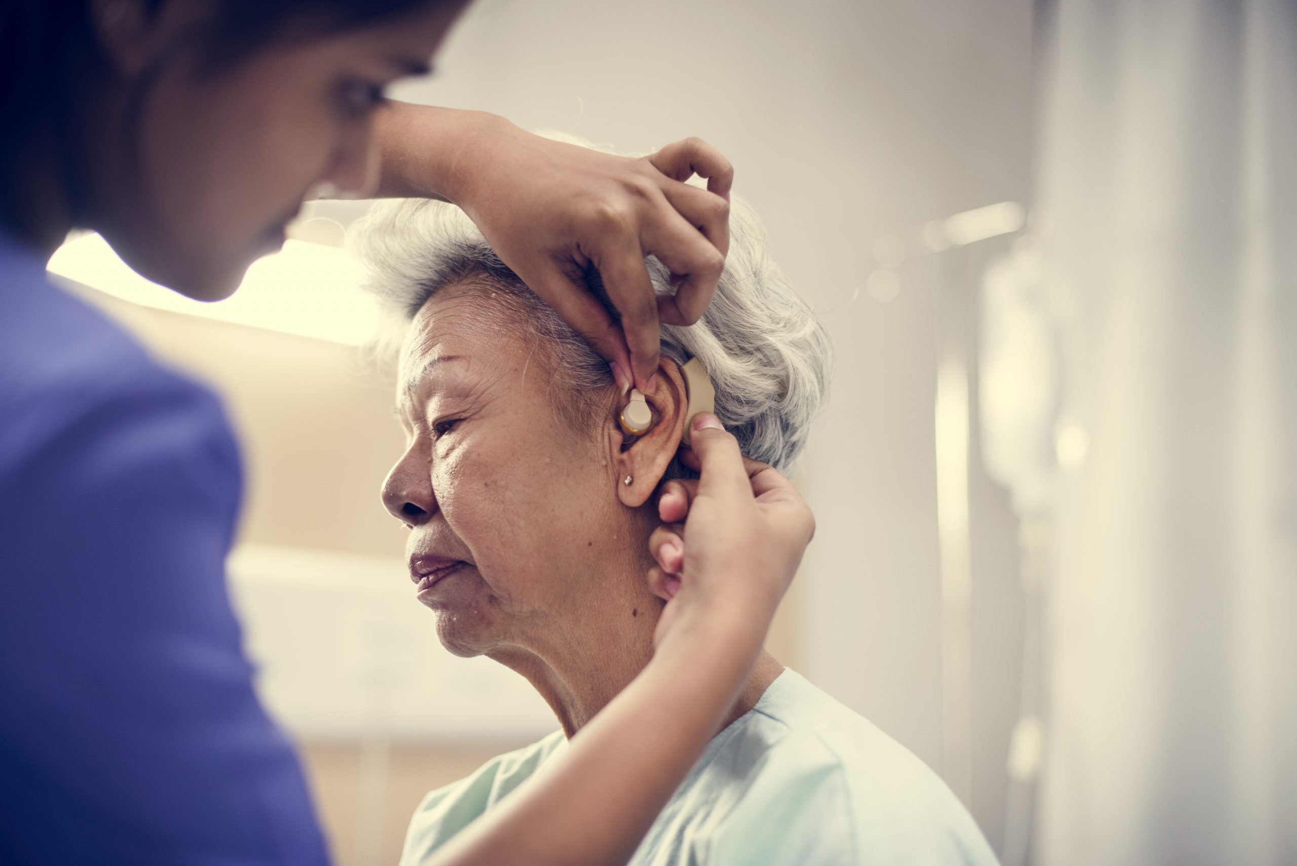 An elderly woman with hearing aid